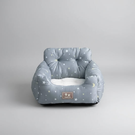 Gray pet bed with star pattern on a carpeted floor, surrounded by home decor elements.
