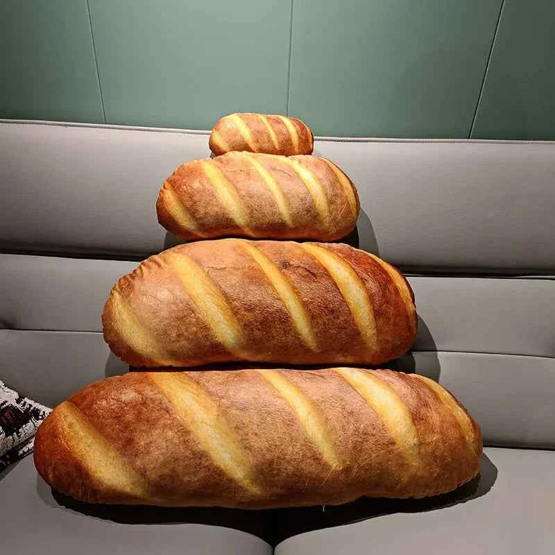 A giant 70cm realistic French baguette bread plush pillow resting on a cozy sofa, showcasing its soft texture and golden-brown simulation design.