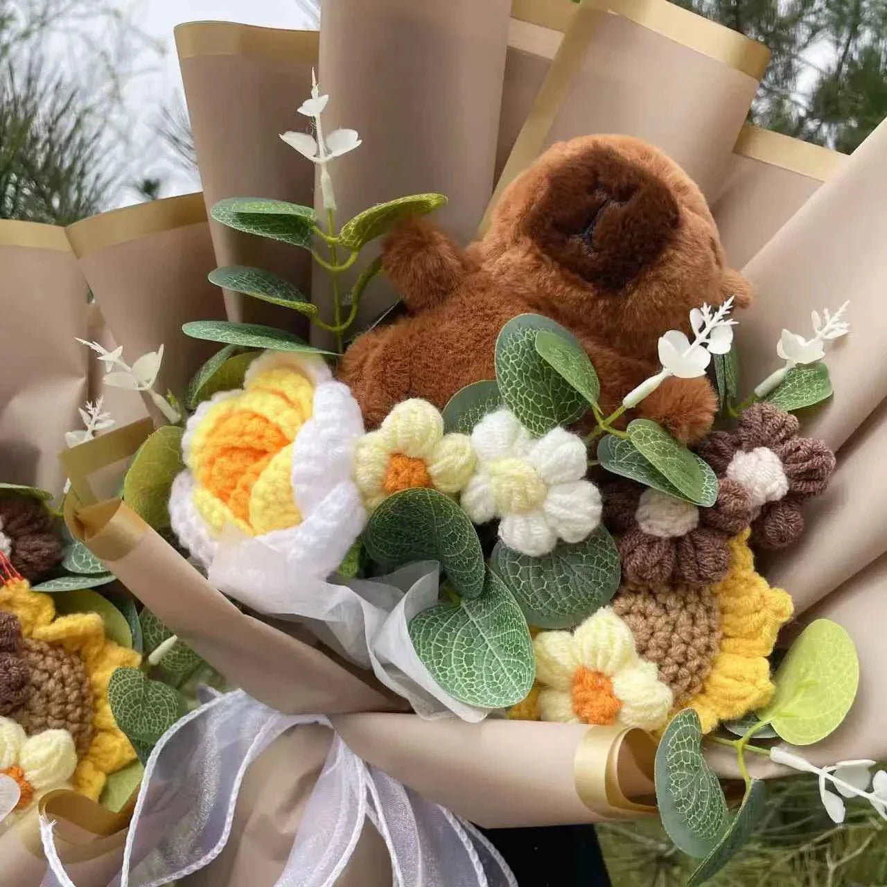 A handcrafted Capybara plush bouquet featuring a cute brown capybara surrounded by yellow crochet sunflowers and wrapped in aesthetic brown paper.