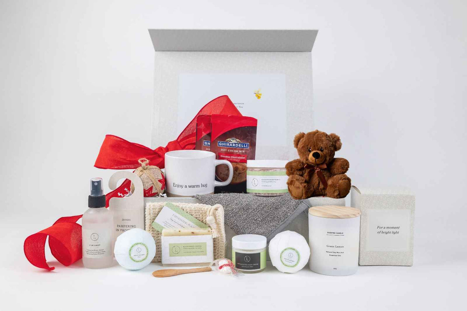 A premium luxury spa gift box featuring eucalyptus bath products, a ceramic mug, a small teddy bear, and a personalized lid with rose gold lettering.