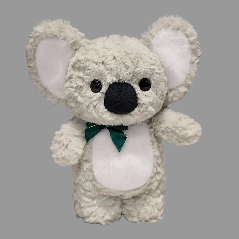 Plush koala toy with a green bow tie on a white surface