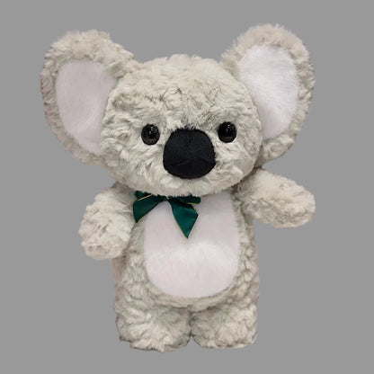 Plush koala toy with a green bow tie on a white surface