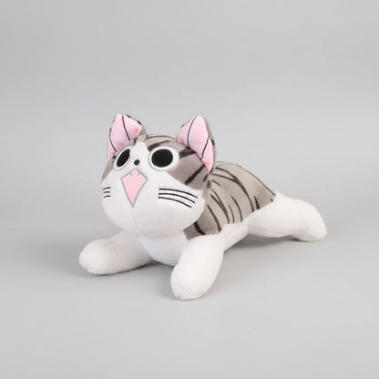 Plush toy cat with pink ears and a white body on a wooden floor.