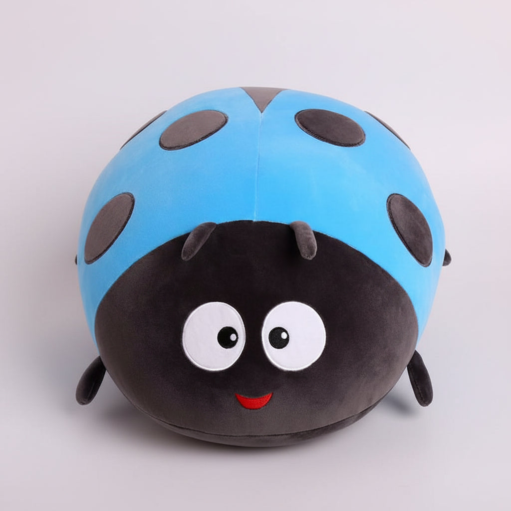 Plush toy shaped like a ladybug with a blue shell and black spots on a white background